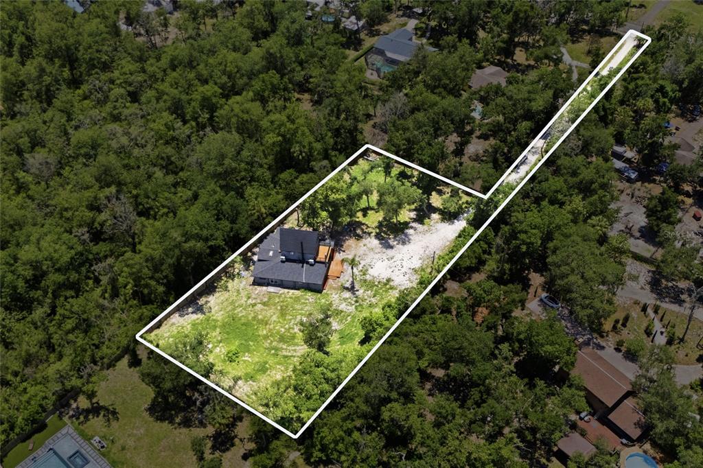 An aerial view shows a house on a large, wooded flag lot with a long driveway — 7210 VALRIE LANE, RIVERVIEW, FL