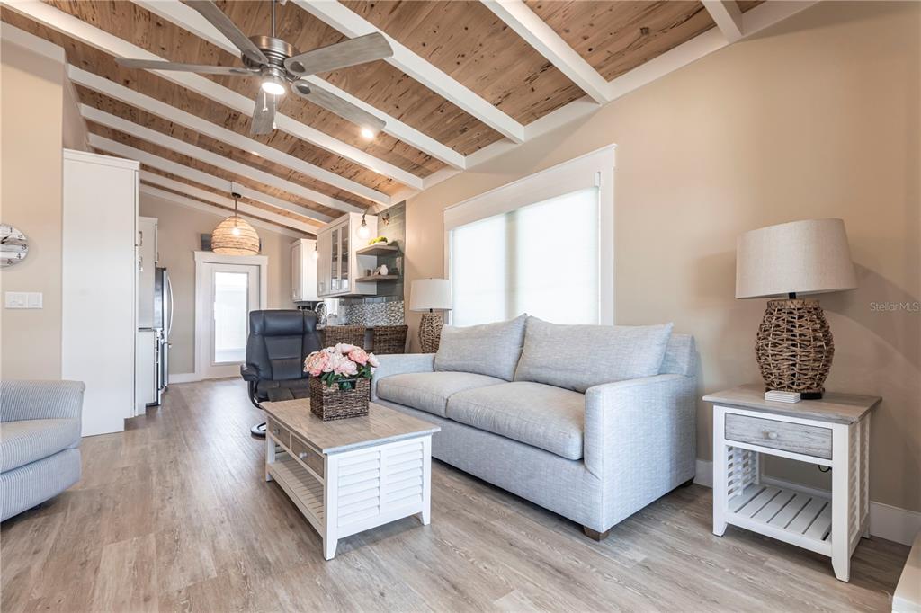 A living room features a light gray sofa, a wooden coffee table, and a vaulted ceiling — 6020 MIDNIGHT PASS ROAD UNIT 39, SARASOTA, FL