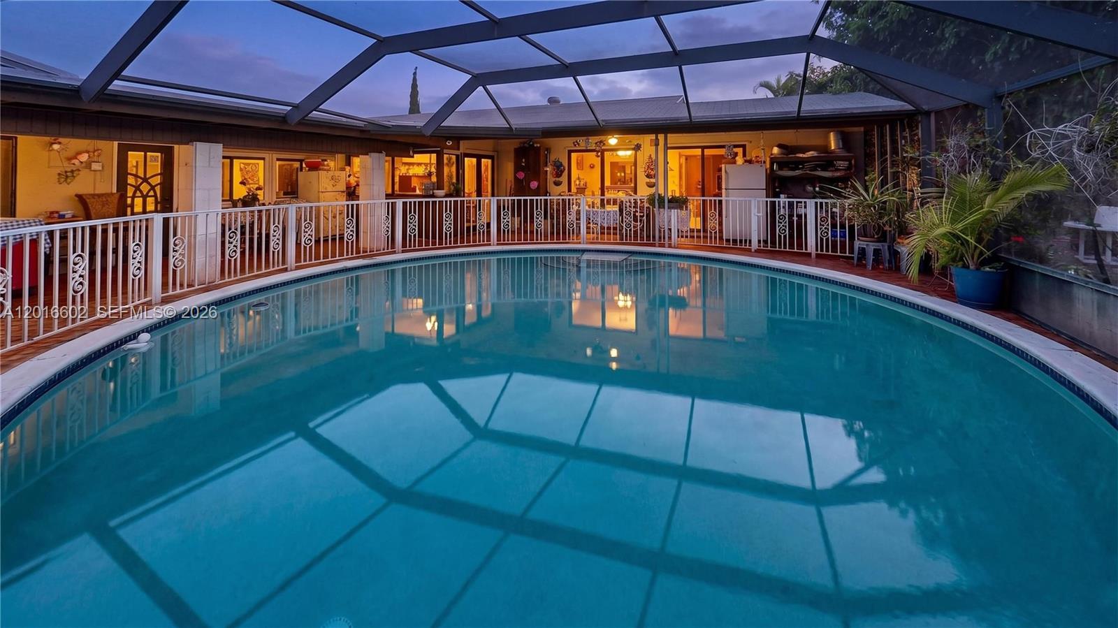 A swimming pool is enclosed by a screened lanai with a white safety fence — 10900 SW 177th Ter, Miami FL 33157, MIAMI, FL