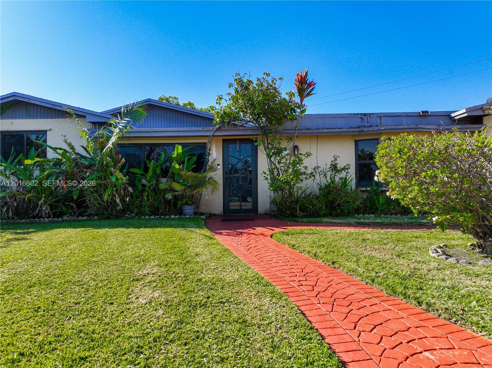 A single-story house features a red brick walkway leading to a dark glass front door — 10900 SW 177th Ter, Miami FL 33157, MIAMI, FL