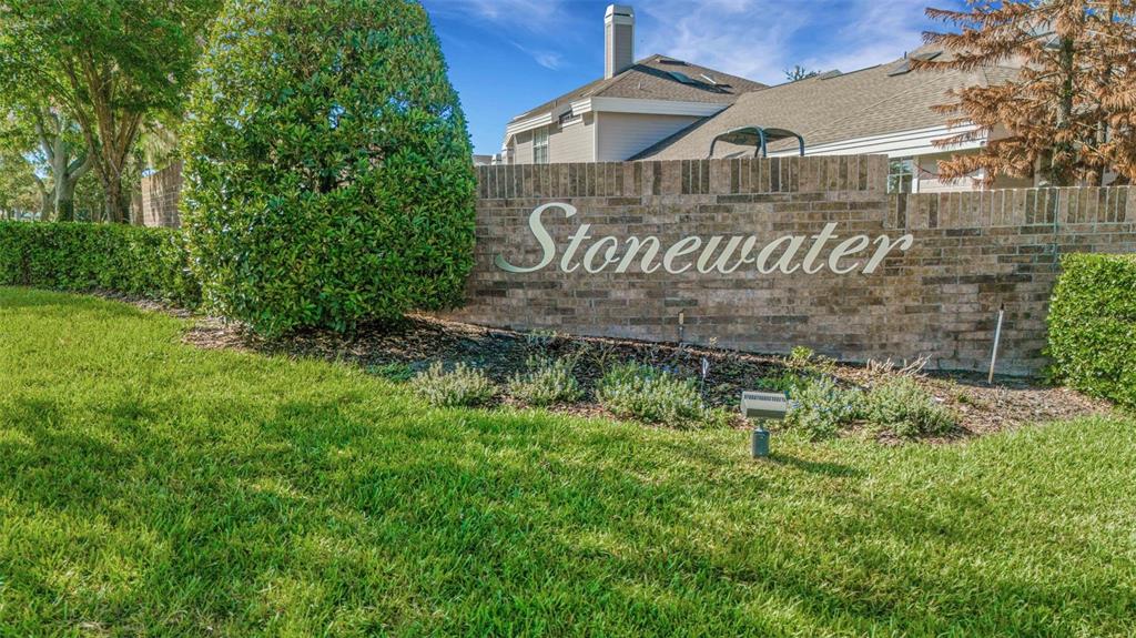 A brick wall with the name Stonewater sits in front of a residential building — 1154 WATERFALL LANE UNIT n/a, LAKELAND, FL