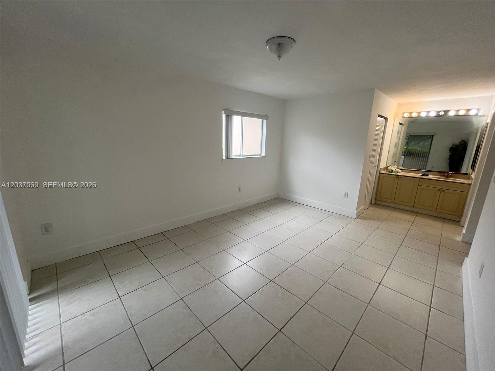 A room with white walls, light-colored floor tiles, a small window, and an attached vanity — 4800 NW 102nd Ave # 10, Doral FL 33178, DORAL, FL