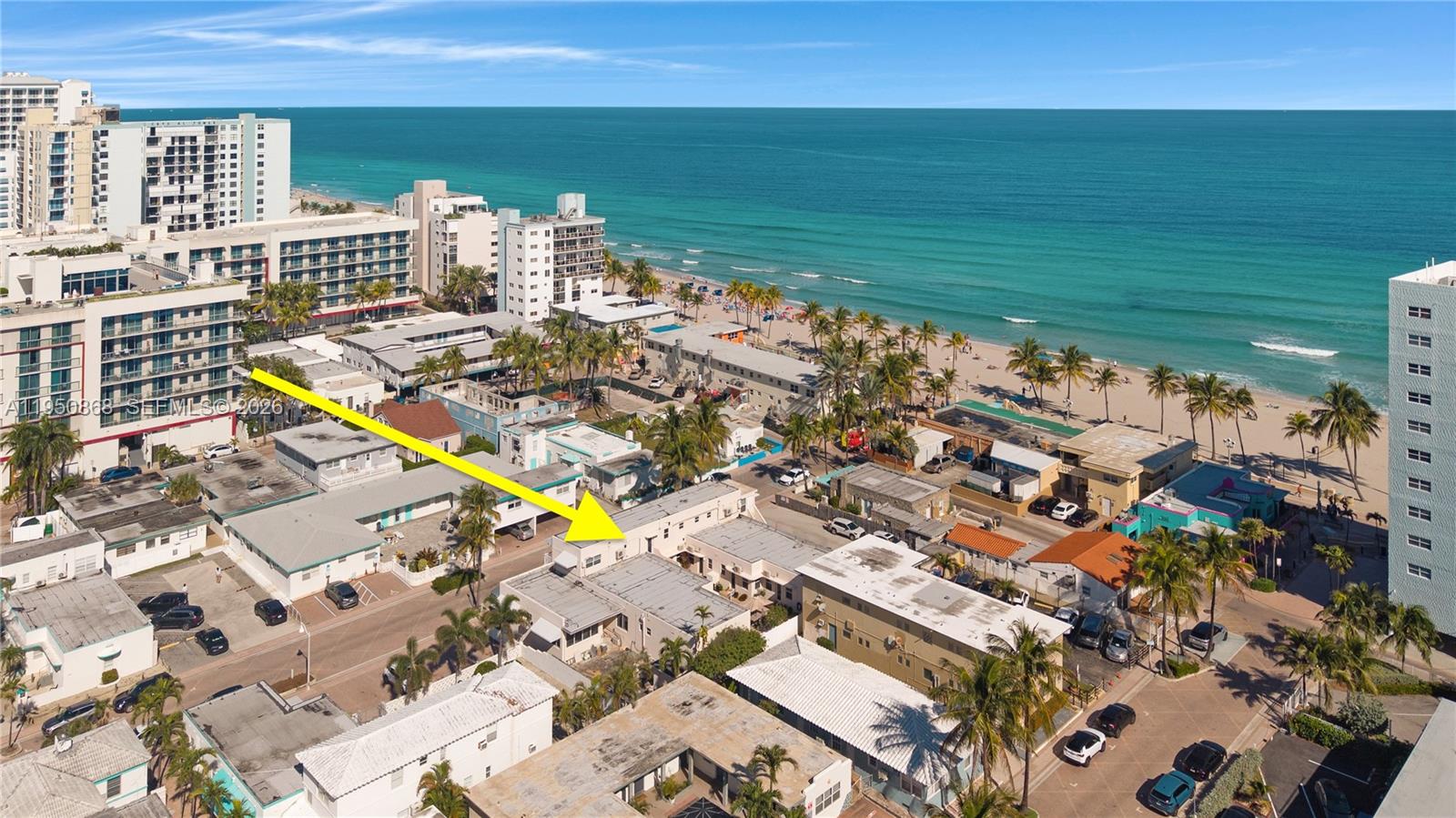An aerial view shows a low-rise building near a sandy beach and the ocean — 320 New York St, Hollywood FL 33019, HOLLYWOOD, FL