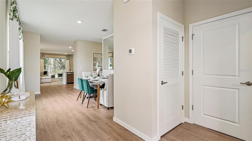 An interior view shows a dining area and hallway with wood-look flooring and white doors — 4007 NW 44TH CIRCLE, OCALA, FL