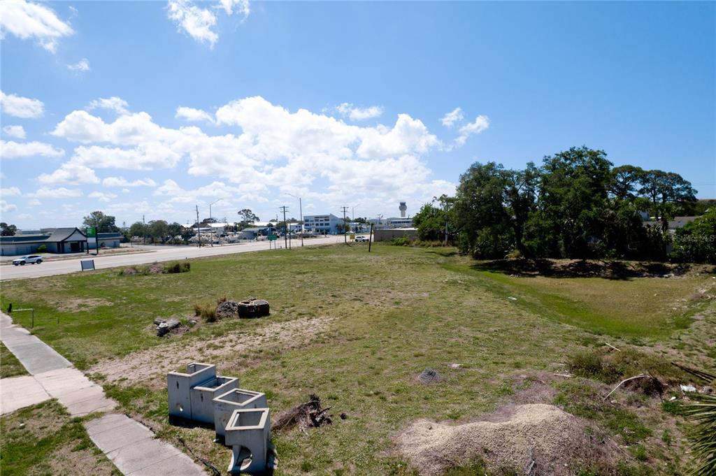 An elevated view of a vacant, grassy lot adjacent to a paved road and sidewalk — 7972 N TAMIAMI TRAIL, SARASOTA, FL