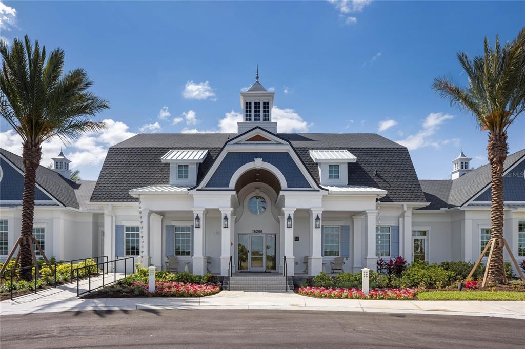 A symmetrical white building with a dark shingled roof and two palm trees in front — 17698 SYLVESTER DRIVE, VENICE, FL