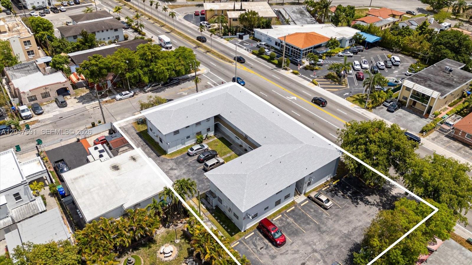 An aerial view shows a U-shaped apartment building with a parking lot and surrounding trees — 3255 W Flagler St # 2, Miami FL 33135, MIAMI, FL