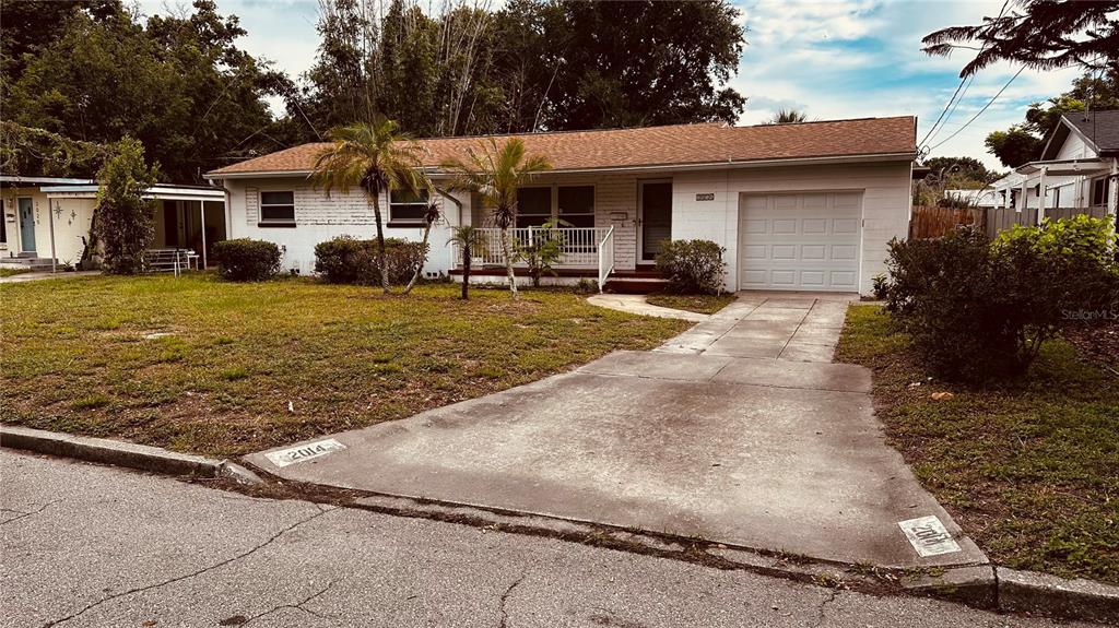 A single-story house with a white exterior, a concrete driveway, and a small front porch — 2014 LINDA STREET, ORLANDO, FL
