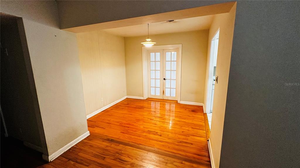 A dining room with hardwood floors, a hanging light fixture, and white French doors — 2014 LINDA STREET, ORLANDO, FL