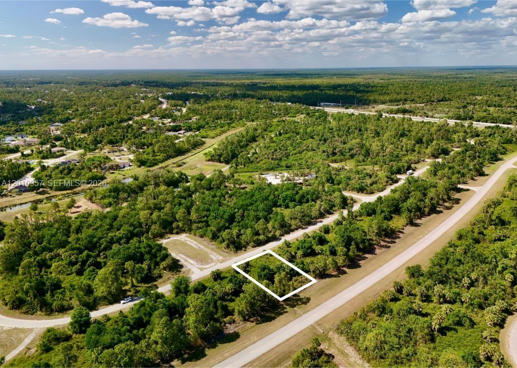 An aerial view shows a rectangular plot of land outlined in white near a road — 0 CUSTER CIR, North Port FL 34288, NORTH PORT, FL