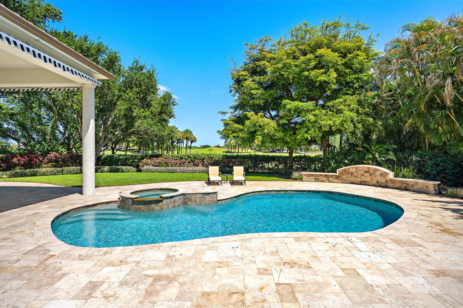 A backyard swimming pool and hot tub with a stone patio and golf course view — 106 Commodore Drive, Jupiter FL 33477, JUPITER, FL