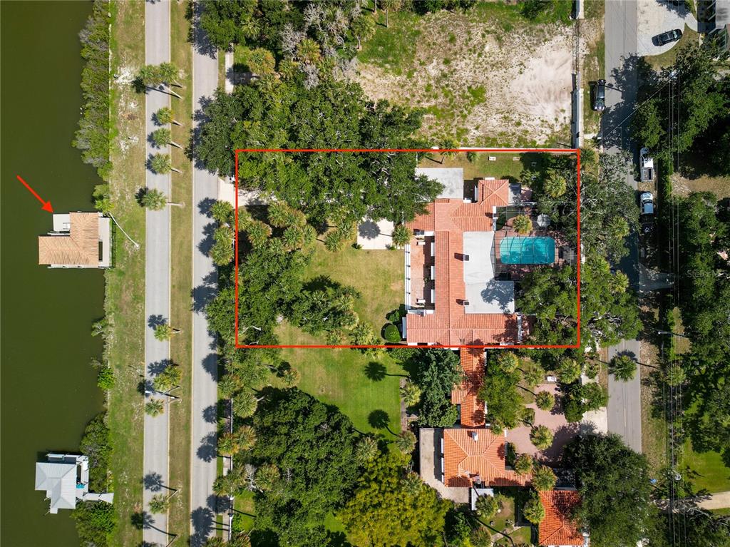 An aerial view shows a house with a red tile roof, pool, and detached dock — 636 N RIVERSIDE DRIVE, NEW SMYRNA BEACH, FL