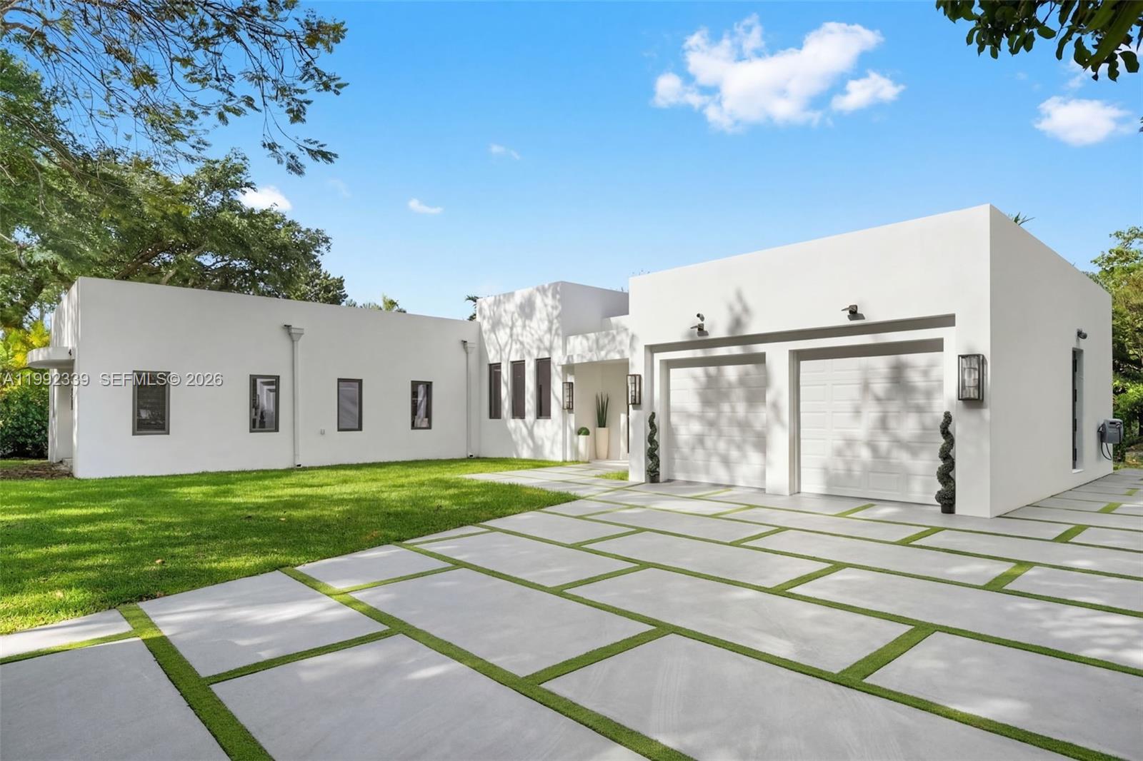 A modern white house with a two-car garage and a concrete paver driveway with grass — 1120 Wallace St, Coral Gables FL 33134, CORAL GABLES, FL