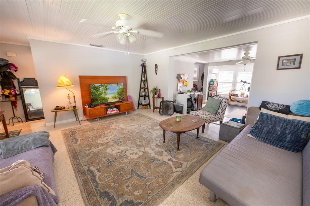 A dining area features a round wooden table, stools, a birdcage, and a white door — 185 WINSON AVENUE, ENGLEWOOD, FL