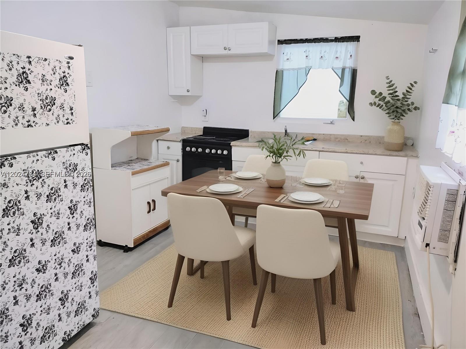 A kitchen features white cabinets, a floral-patterned refrigerator, and a dining table with four chairs — 5647 NW 5th Ct # B, Miami FL 33127, MIAMI, FL