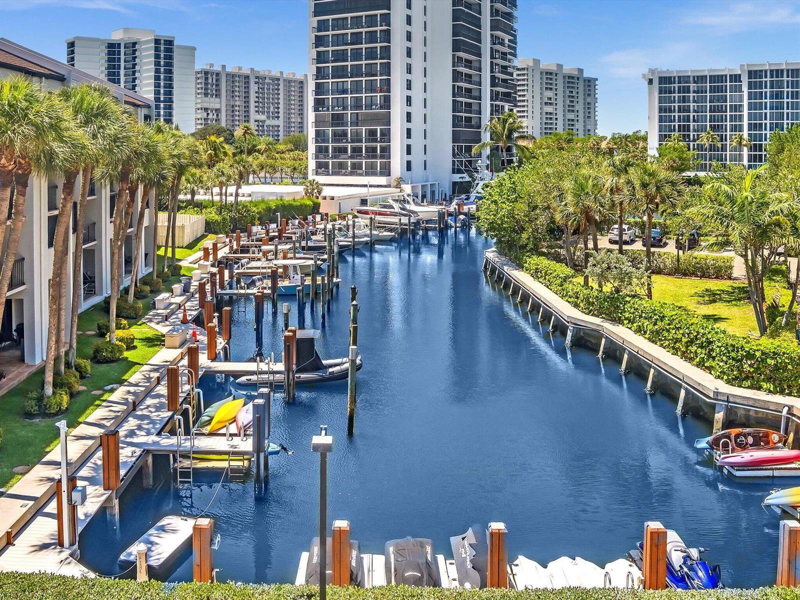 An elevated view of a canal lined with boat slips, palm trees, and residential buildings — 4600 S Ocean Boulevard # 502, Highland Beach FL 33487, HIGHLAND BEACH, FL