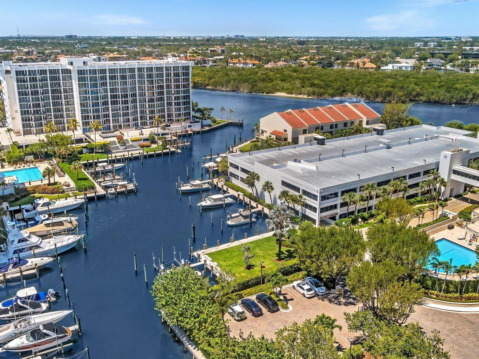 An aerial view shows a marina with docked boats, a large apartment building, and parking — 4600 S Ocean Boulevard # 502, Highland Beach FL 33487, HIGHLAND BEACH, FL