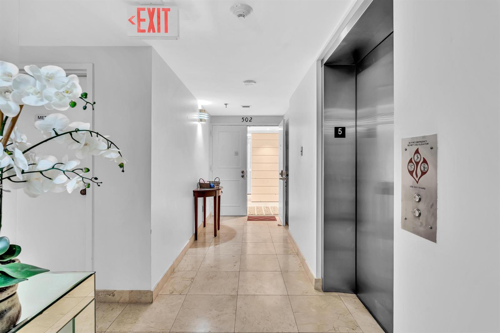 A hallway with tile flooring, an elevator, and a door labeled 502 — 4600 S Ocean Boulevard # 502, Highland Beach FL 33487, HIGHLAND BEACH, FL