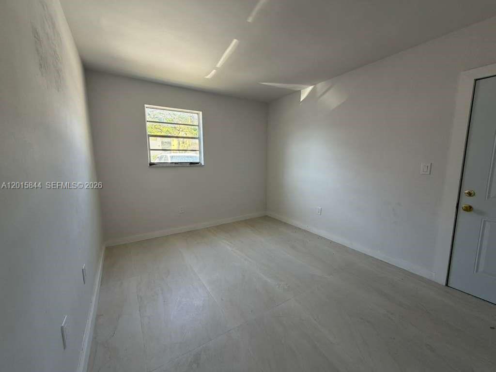 An empty bedroom features light-colored tile flooring, white walls, and a single window — 1461 SW 7th St # 1, Miami FL 33135, MIAMI, FL
