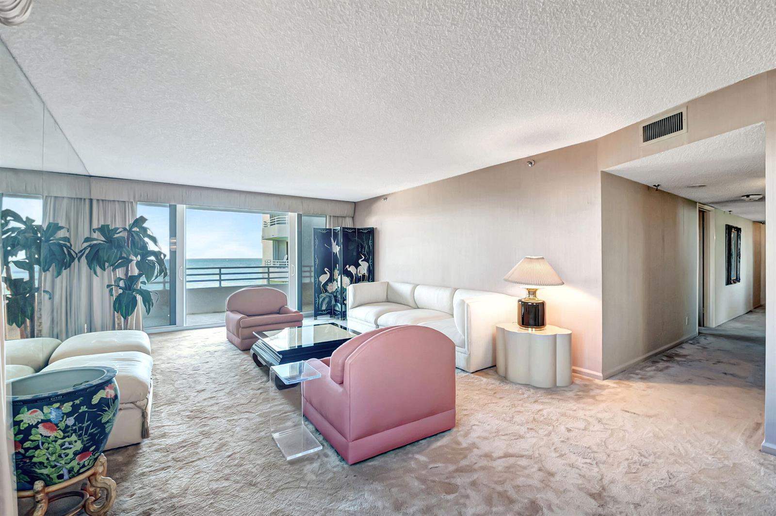 A living room features a white sofa, pink armchairs, a glass coffee table, and ocean views — 3407 S Ocean Boulevard # 4d, Highland Beach FL 33487, HIGHLAND BEACH, FL