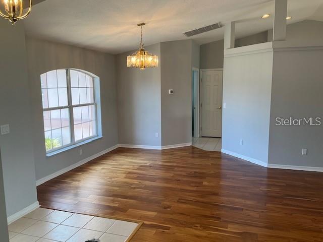 A dining area features hardwood flooring, a chandelier, and a large window with white trim — 4921 NW 33RD LANE, OCALA, FL