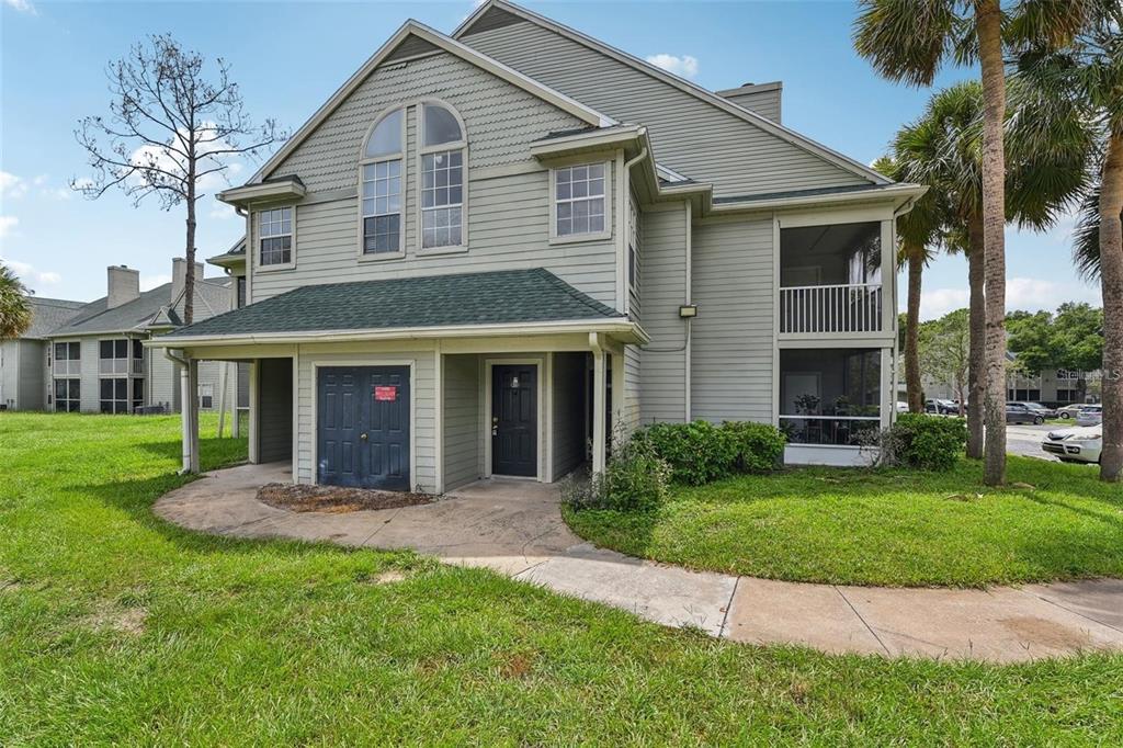 A two-story residential building with light green siding, a dark roof, and a screened-in porch — 6088 WESTGATE DRIVE UNIT 201, ORLANDO, FL