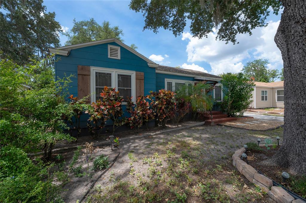 A blue, single-story house with wooden shutters and a large tree in the front yard — 912 CORNELIUS AVENUE, TAMPA, FL