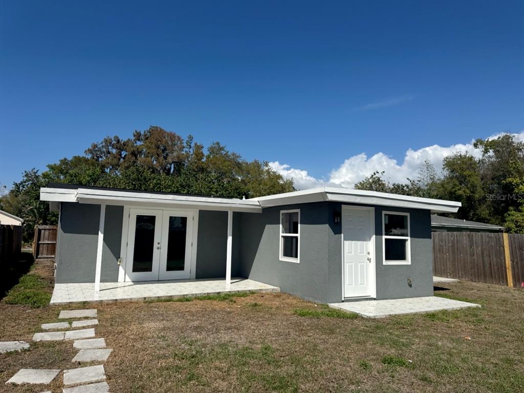 A gray, single-story house with a white door, French doors, and two tiled patios — 5520 20TH AVENUE S, GULFPORT, FL