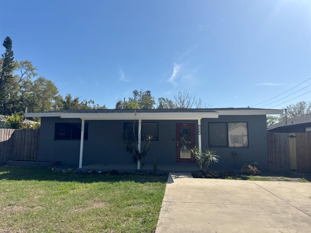 A single-story gray house with a flat roof, covered porch, and a concrete driveway — 5520 20TH AVENUE S, GULFPORT, FL