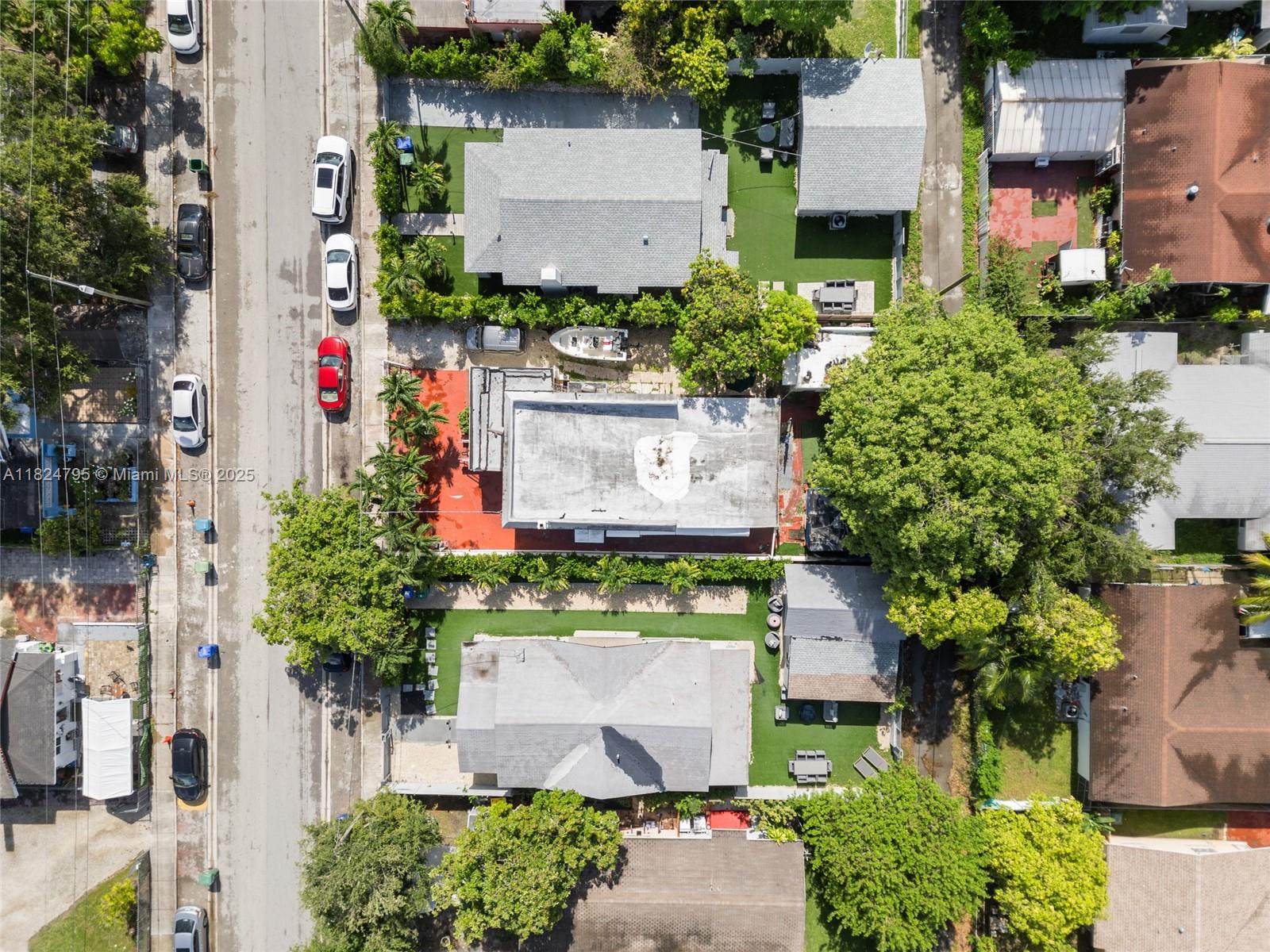 An aerial view shows several residential properties with houses, green lawns, and parked cars — 50 NW 34th Ter, Miami FL 33127, MIAMI, FL