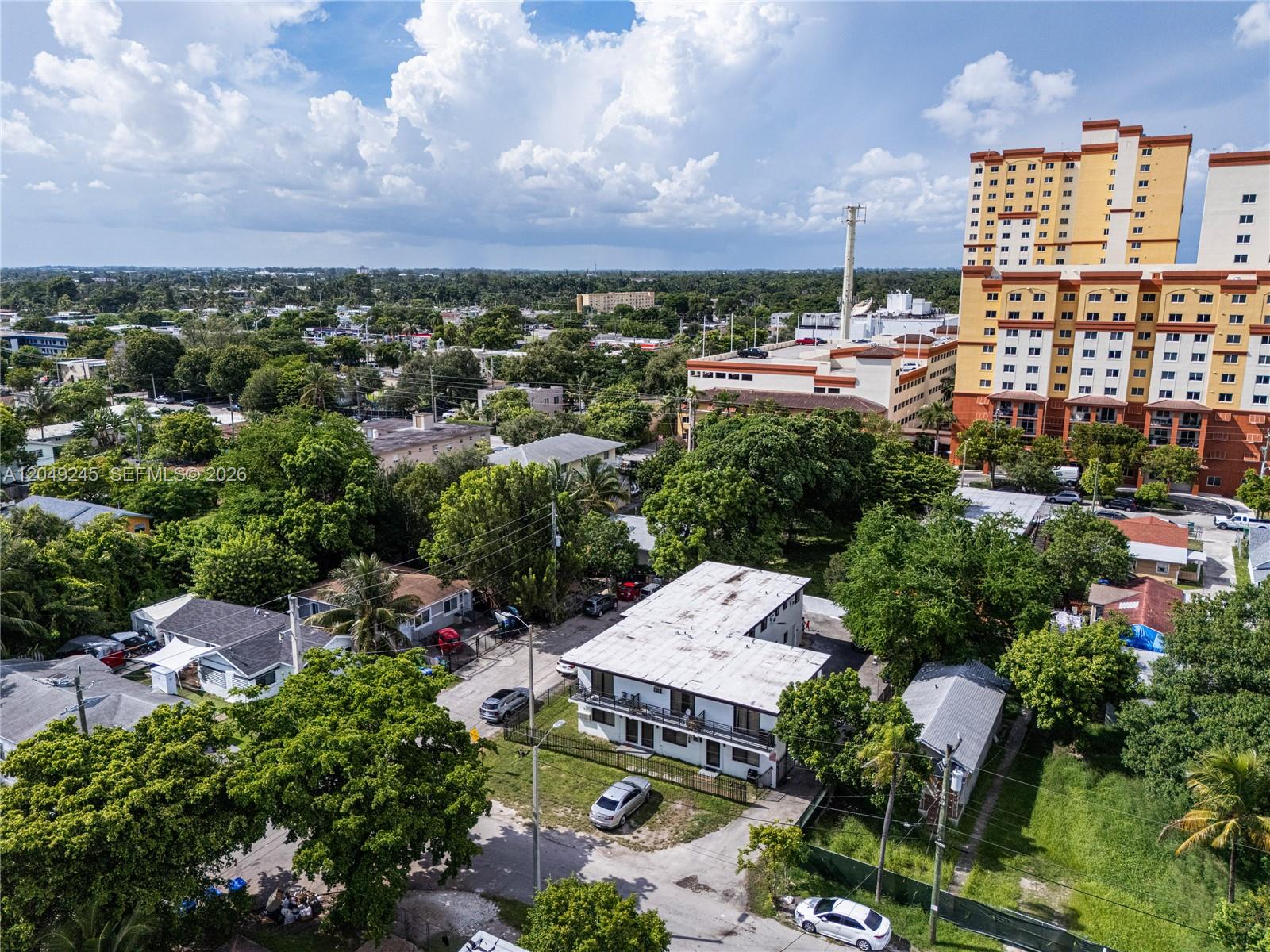 An aerial view shows a two-story apartment building surrounded by trees and residential houses — 131 NE 77th St, Miami FL 33138, MIAMI, FL