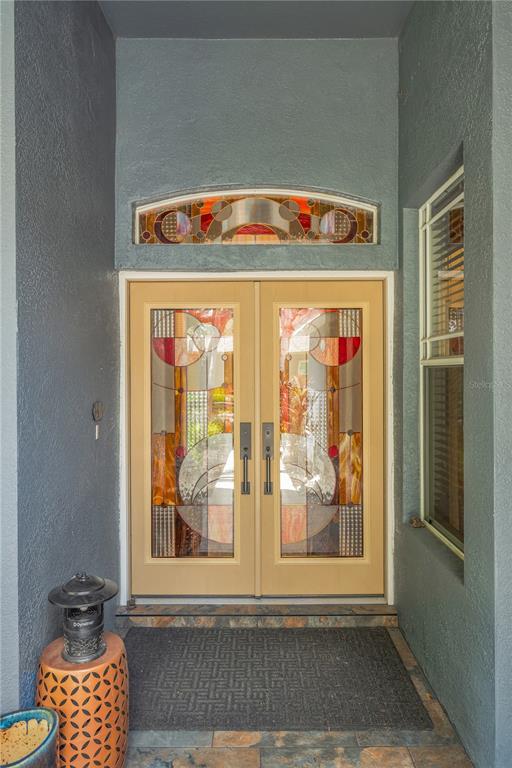 A front entryway features double doors with stained glass inserts and a matching arched transom — 1128 LUMSDEN TRACE CIRCLE, VALRICO, FL