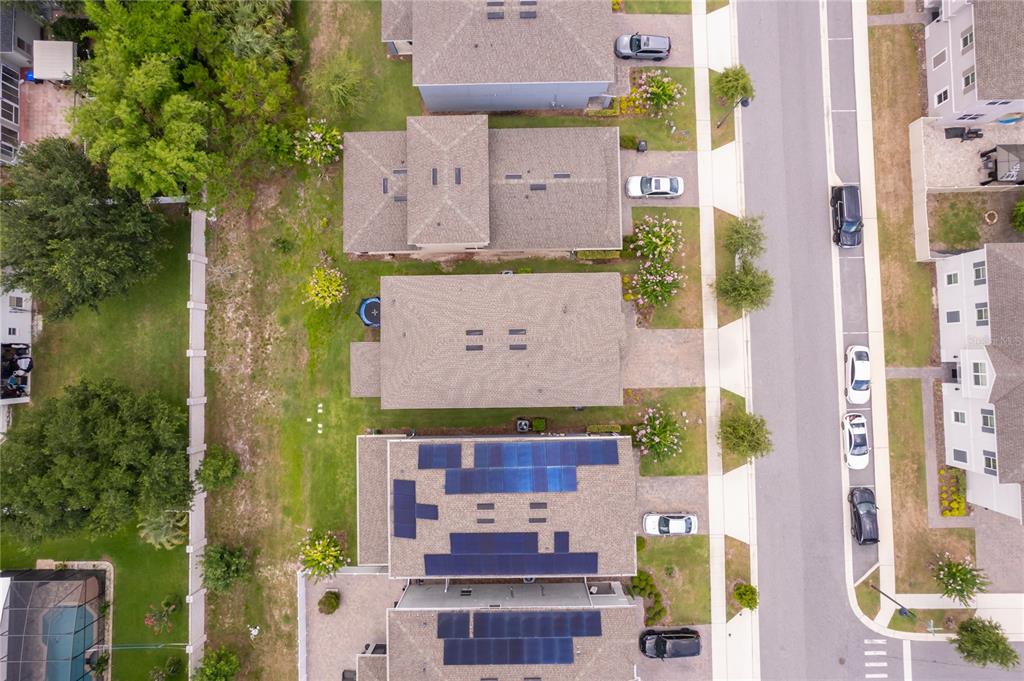 An aerial view shows a row of suburban houses with solar panels on some roofs — 2229 EMERALD SPRINGS, APOPKA, FL