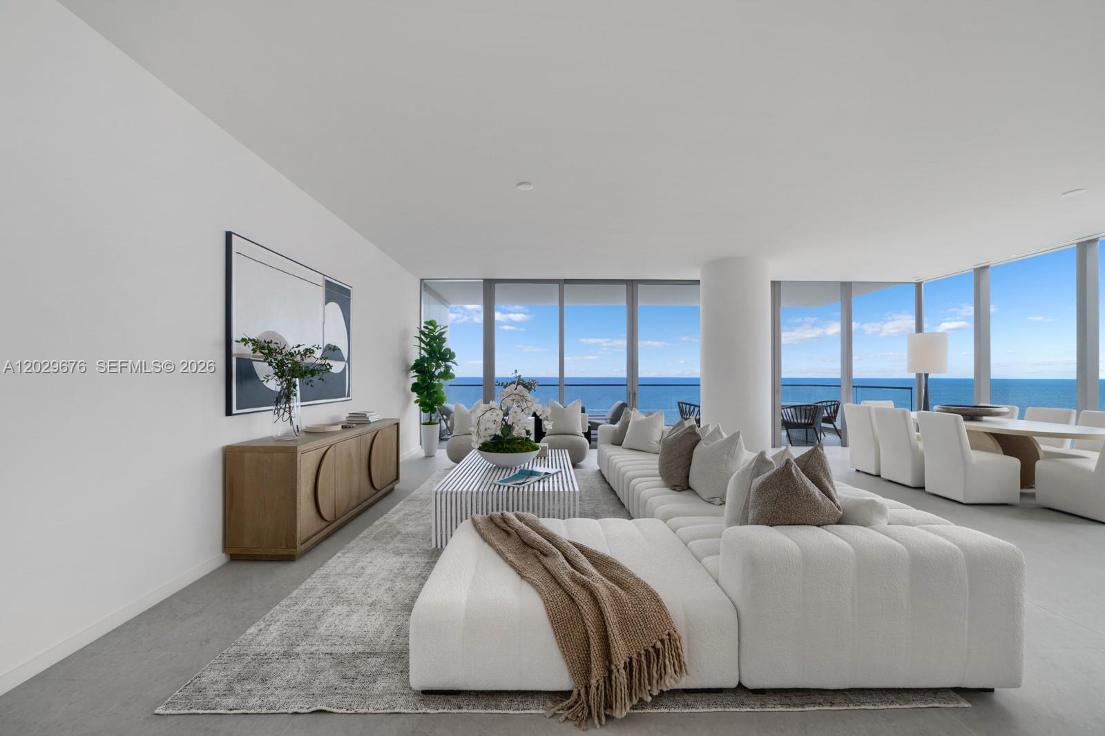 A modern living room features a large white sectional, wooden credenza, and floor-to-ceiling ocean views — 2000 S Ocean Dr # 15B, Hallandale Beach FL 33009, HALLANDALE BEACH, FL