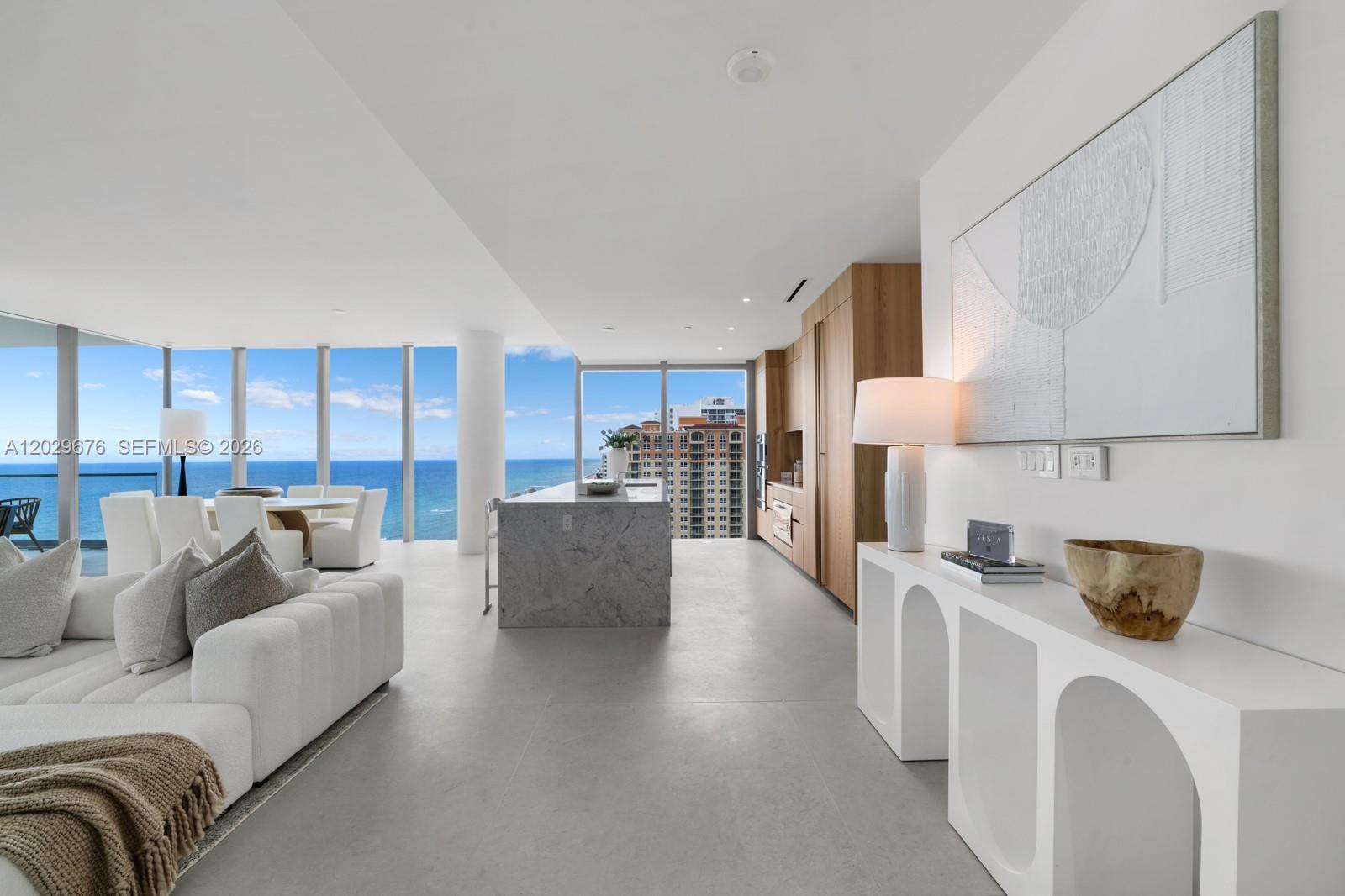 A modern open-concept living area features a marble kitchen island and floor-to-ceiling ocean views — 2000 S Ocean Dr # 15B, Hallandale Beach FL 33009, HALLANDALE BEACH, FL