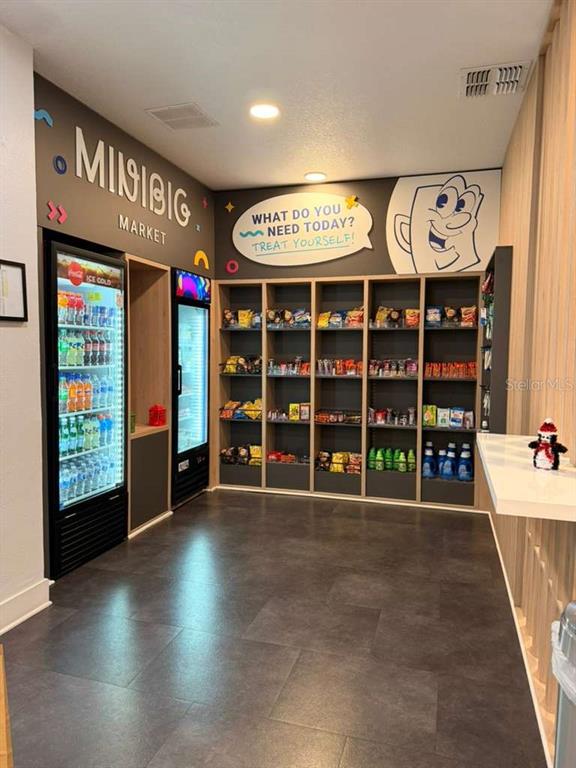 A small market area features two glass-front refrigerators and open shelving stocked with snacks — 2930 POLYNESIAN ISLE BOULEVARD UNIT 245, KISSIMMEE, FL