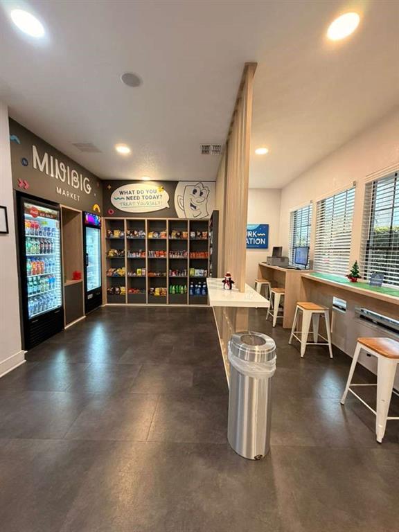A modern convenience market area features shelving, a refrigerator, and a counter with bar stools — 2930 POLYNESIAN ISLE BOULEVARD UNIT 245, KISSIMMEE, FL