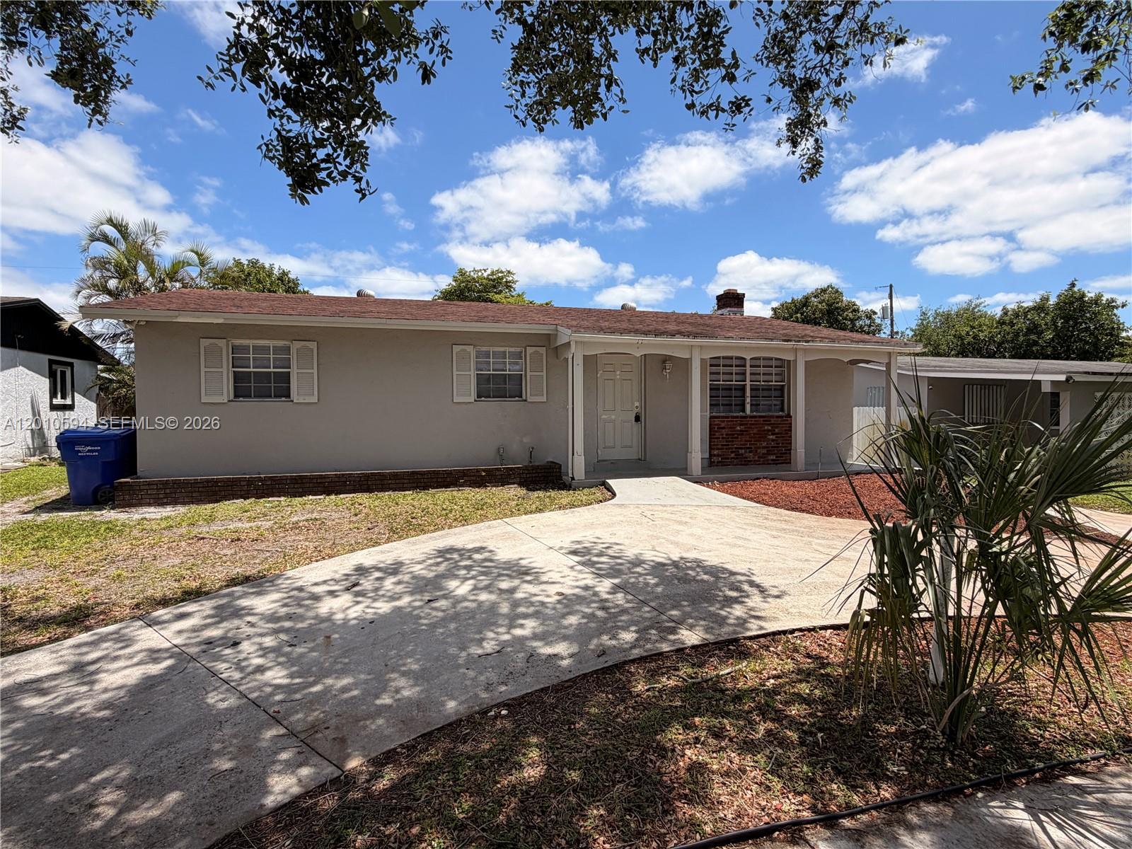 A single-story house with a beige exterior, a concrete driveway, and a covered front porch — 3011 N 74th Ave, Hollywood FL 33024, HOLLYWOOD, FL