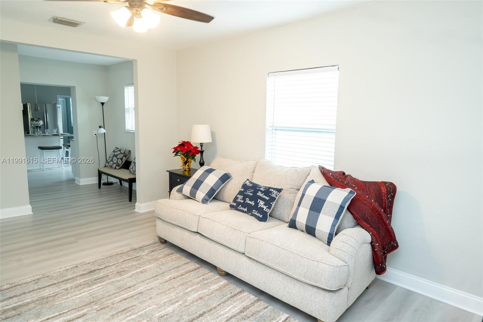A living room features a beige sofa, a patterned area rug, and a doorway leading elsewhere — 2230 SW 60th Ct, Miami FL 33155, MIAMI, FL