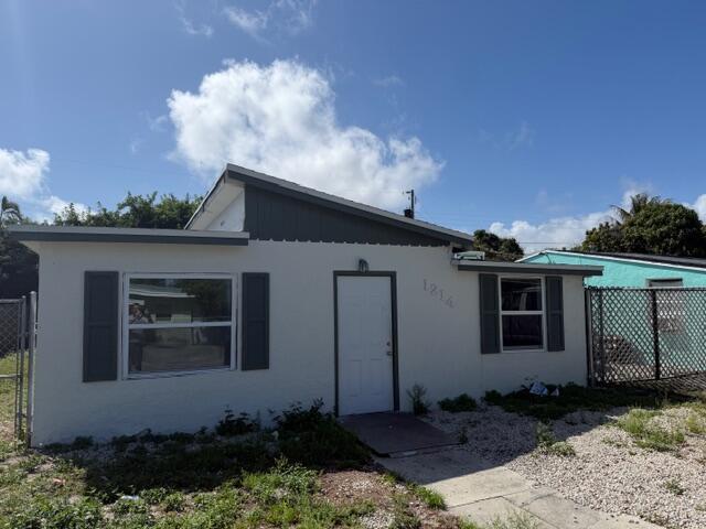 A single-story house with a white exterior, dark shutters, and a shed roof — 1214 Highview Road, Lake Worth FL 33462, LAKE WORTH, FL