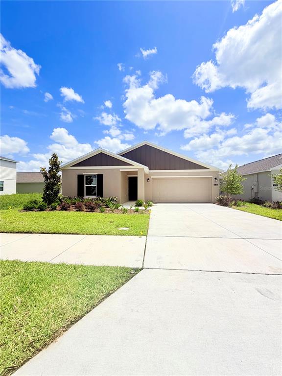 A single-story suburban house features a tan stucco exterior, dark brown gables, and a driveway — 5135 MAGNOLIA DRIVE, DAYTONA BEACH, FL