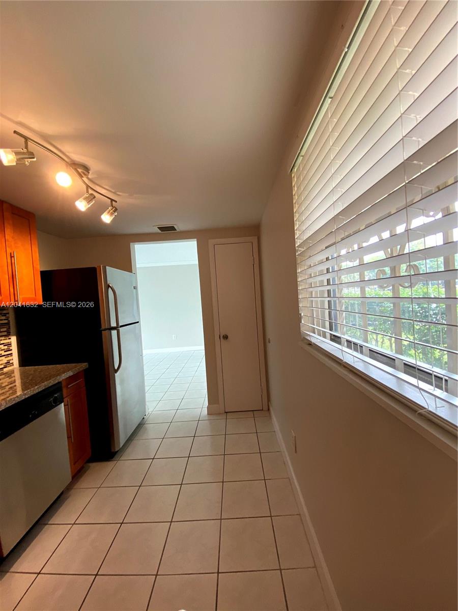 A kitchen with tile flooring, stainless steel appliances, and a window with white blinds — 9280 FONTAINEBLEAU BL # 103, Miami FL 33172, MIAMI, FL