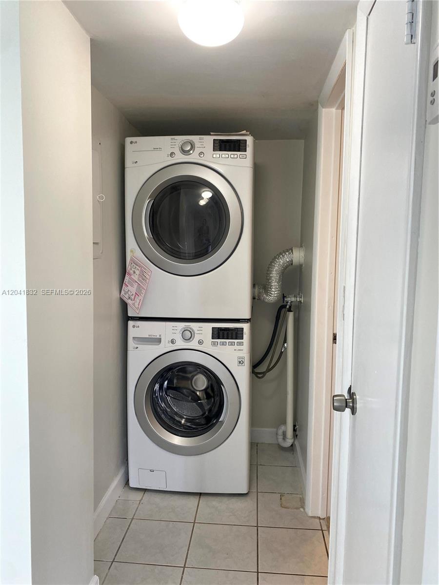 A stacked LG washer and dryer unit is installed in a small tiled laundry closet — 9280 FONTAINEBLEAU BL # 103, Miami FL 33172, MIAMI, FL