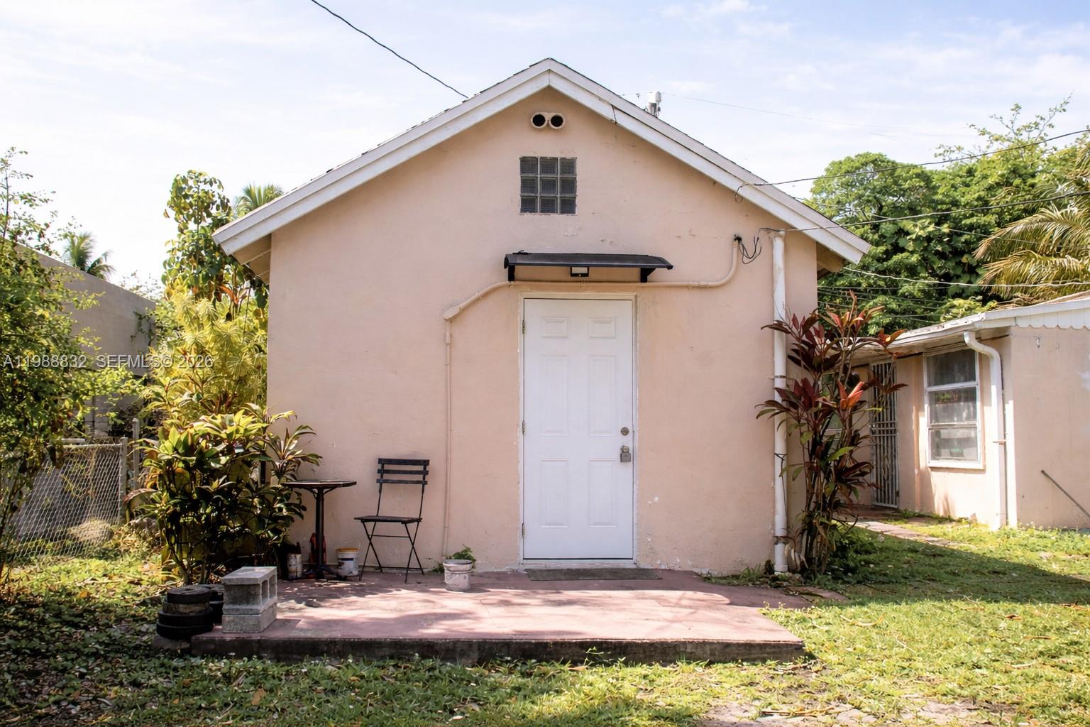 A small, peach-colored detached building with a white door and a concrete patio — 6250 NW Miami Pl # 2, Miami FL 33150, MIAMI, FL