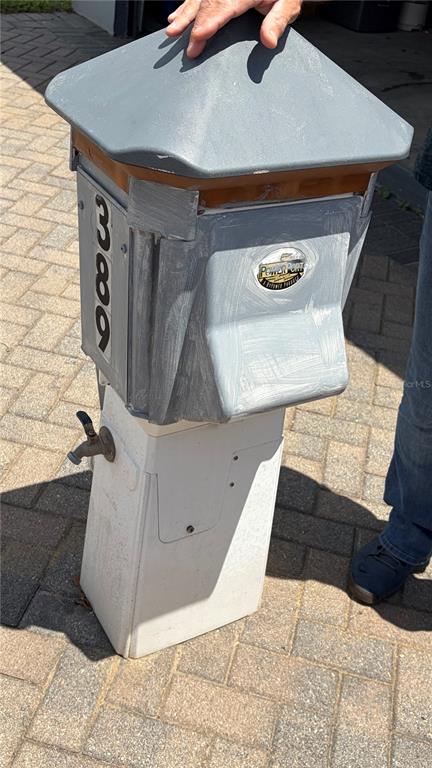 A gray and white utility pedestal with a faucet and house number stands on pavers — 389 NOLANE LANE, POLK CITY, FL