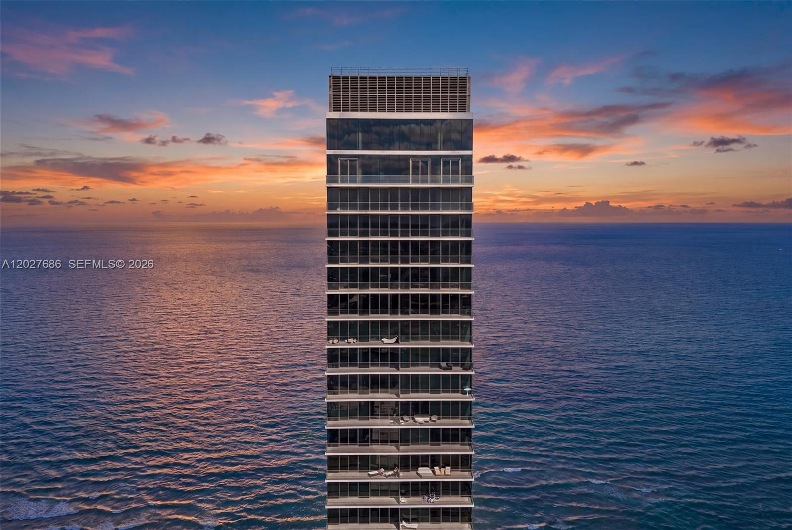 An aerial view shows the exterior facade of a tall, modern glass residential skyscraper — 2000 S Ocean Dr # 33A, Hallandale Beach FL 33009, HALLANDALE BEACH, FL