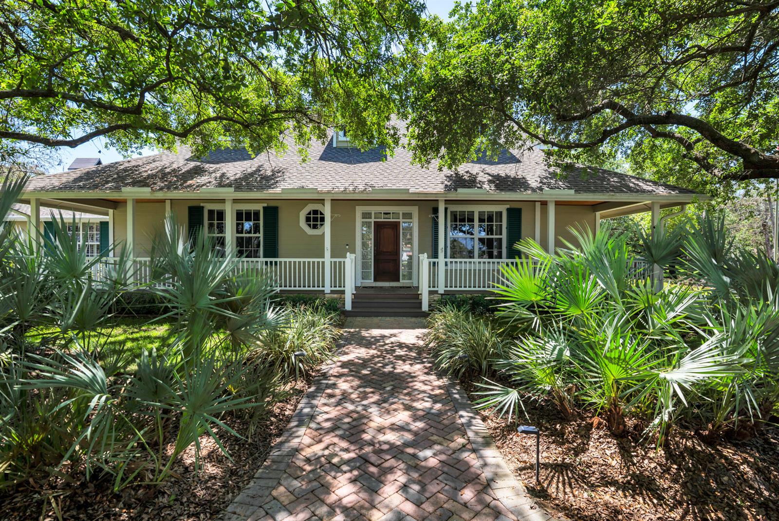 A single-story house with a wrap-around porch and brick walkway surrounded by palm trees — 14366 Belmont Trace, Wellington FL 33414, WELLINGTON, FL