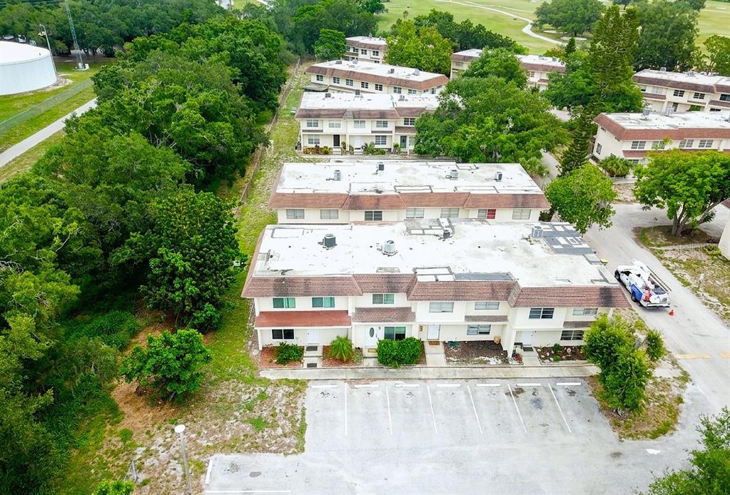 An aerial view shows multi-story apartment buildings with flat roofs and an adjacent parking lot — 309 AMHERST AVENUE UNIT 51, SARASOTA, FL