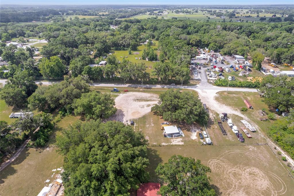An aerial view shows a rural property with a small building, trees, and parked vehicles — 1751 E HIGHWAY 329, CITRA, FL