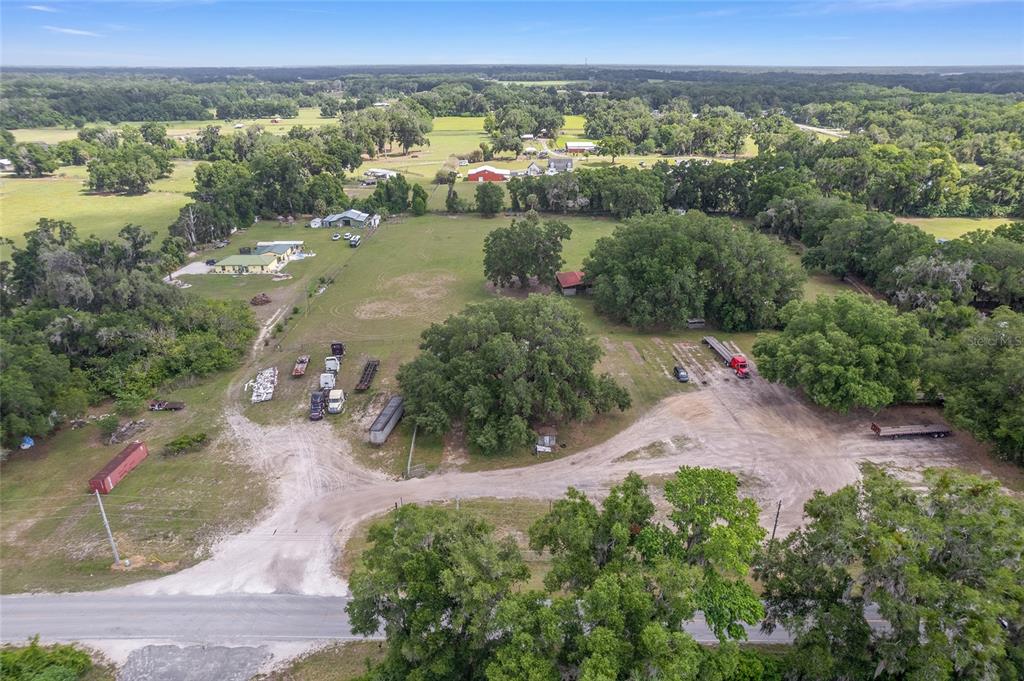 An aerial view shows a rural property with a house, outbuildings, and several parked vehicles — 1751 E HIGHWAY 329, CITRA, FL